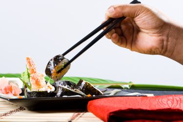 Picking up sushi with chopsticks