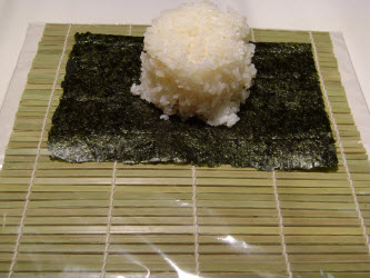 Placing 1 cup of rice on 5x7 inch nori sheet for spicy tuna roll