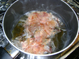 Katsuobushi added to water and sake for dashi