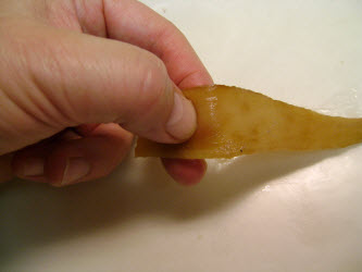 Using fingernail to test kampyo gourd strips for doneness