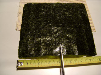 Measuring 8 inch side of nori to cut it in half to 4 inches