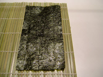 Lay the nori sheet on the sushi mat with the 7 inch side closest to you...leave 3 or 4 slats visible...