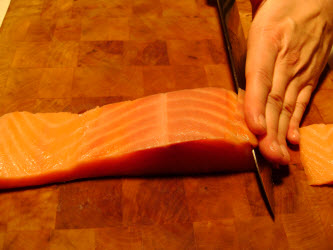 Slicing cold smoked salmon 1/8 inch thick at 45 degree angle for nigiri or sashimi