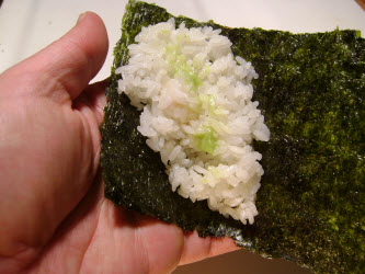 Adding a swipe of wasabi to sushi rice for hand roll