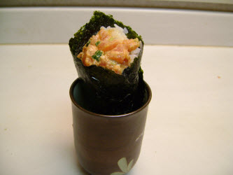 Spicy tuna hand roll in a japanese tea cup