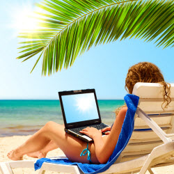 Woman working her business on a laptop on the Beach