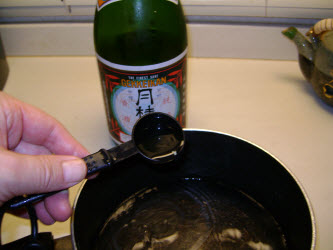 Adding sake to water in a pot for dashi