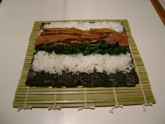 Adding spinach across sushi rice for futomaki