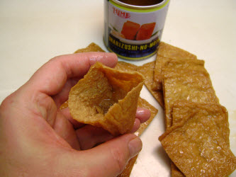 Opening the pocket of cooked and seasoned fried bean curd bag