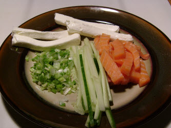 Ingredients for a Philadelphia roll: slivered cucumbers, green onions, cream cheese and smoked salmon