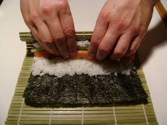 Put thumbs under the mat closest to you and lift up using fingers to hold fillings in place...