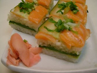 Finished salmon and cucumber oshi sushi on sushi plate