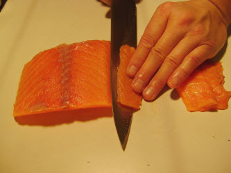 Slicing premium scottish salmon 1/8 inch thick at 45 degree angle for nigiri or sashimi