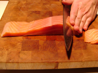 Slicing cold smoked salmon 1/8 inch thick at 45 degree angle for nigiri or sashimi