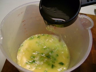 Adding 1/4 cup of dashi to eggs for tamago