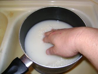 Washing white rice. Drain and repeat 4 to 6 times till water is fairly clear